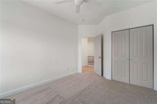 unfurnished bedroom with baseboards, a ceiling fan, lofted ceiling, carpet, and a closet