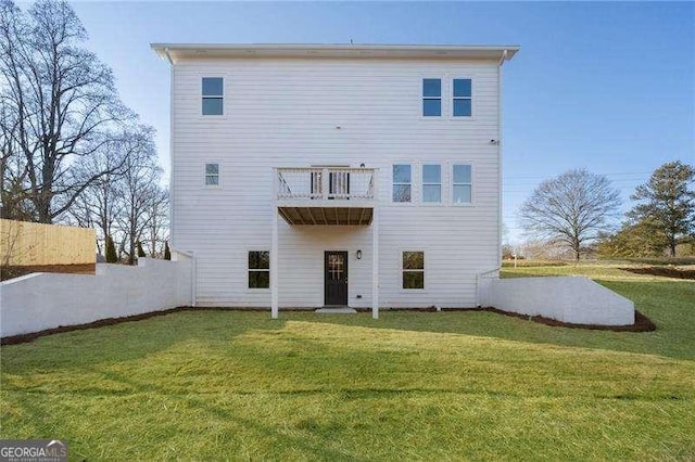 back of property with a lawn and a balcony