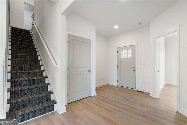 foyer featuring stairway, recessed lighting, wood finished floors, and baseboards