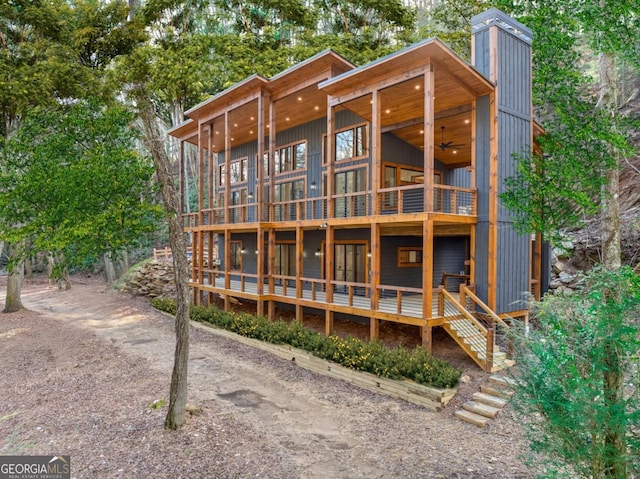 rear view of property featuring a ceiling fan