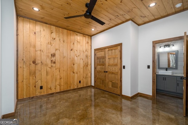 foyer with wooden ceiling, wooden walls, and baseboards