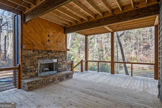 wooden terrace with an outdoor stone fireplace