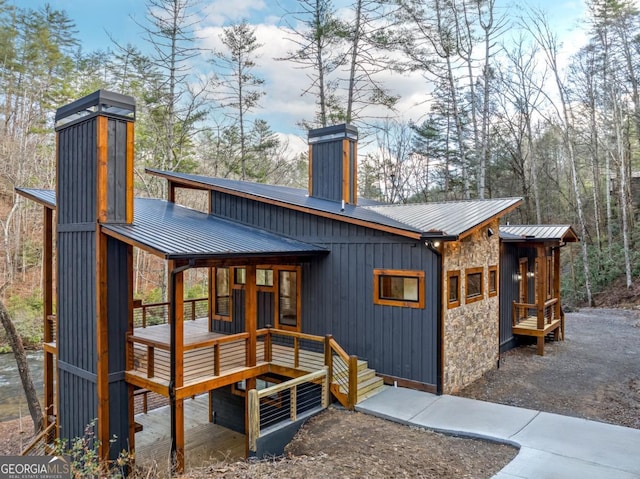 exterior space featuring board and batten siding, stone siding, metal roof, and a standing seam roof