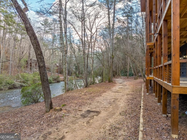 view of yard featuring a water view and a forest view