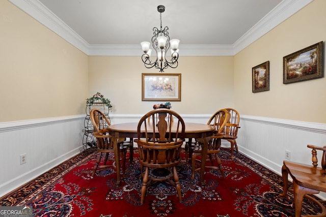 dining area with baseboards, wainscoting, wood finished floors, an inviting chandelier, and crown molding