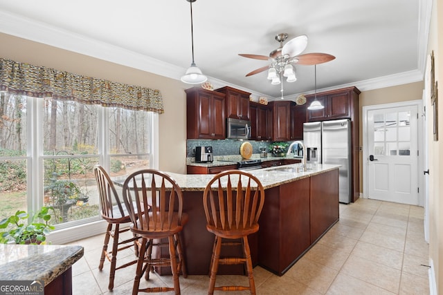 kitchen with light stone countertops, a sink, appliances with stainless steel finishes, decorative backsplash, and crown molding