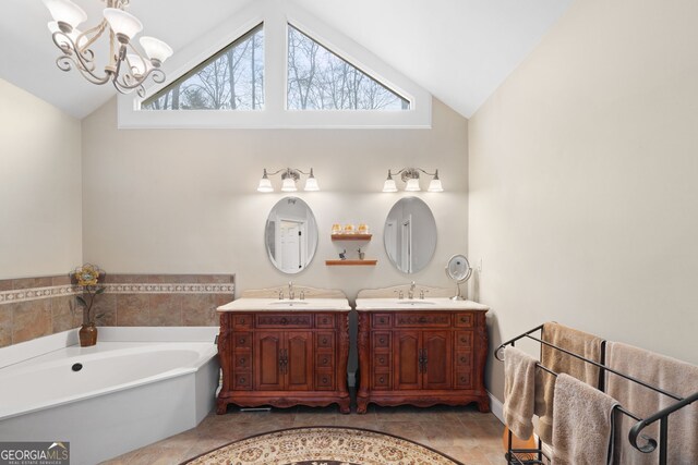 bathroom featuring a sink, two vanities, a notable chandelier, and lofted ceiling