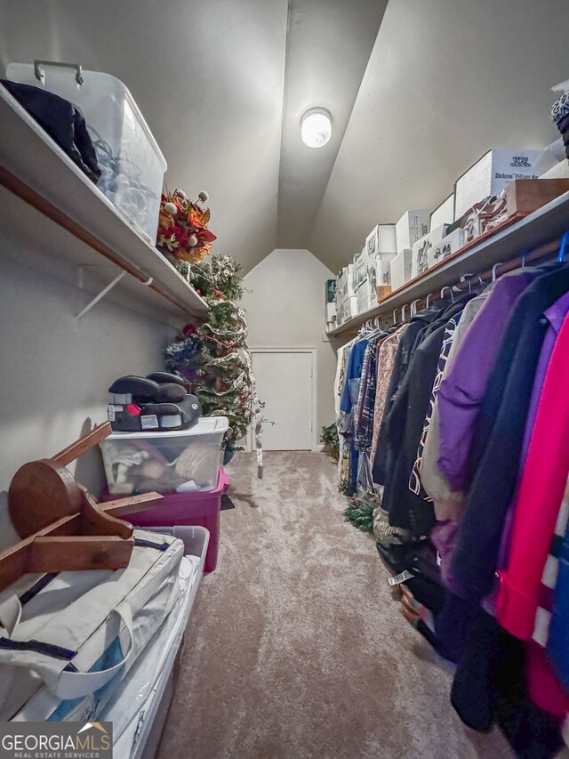 walk in closet with lofted ceiling and carpet flooring