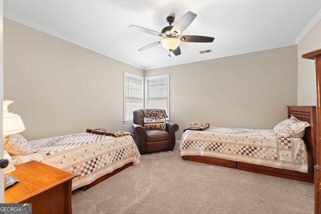 bedroom featuring carpet floors, a ceiling fan, visible vents, and crown molding