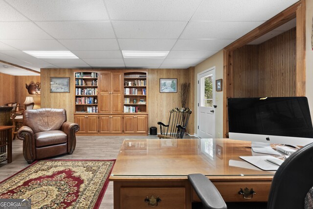 office area featuring light wood finished floors and wooden walls