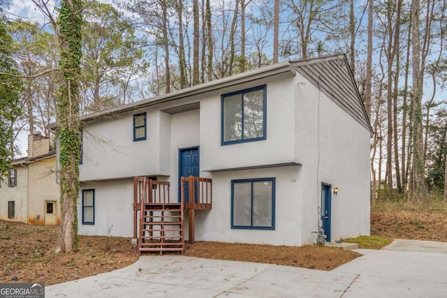 view of front of house with a chimney and stucco siding