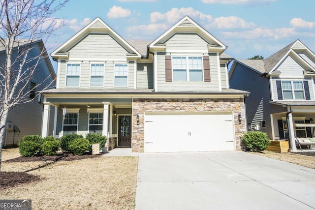 view of front of house with an attached garage, stone siding, a porch, and concrete driveway