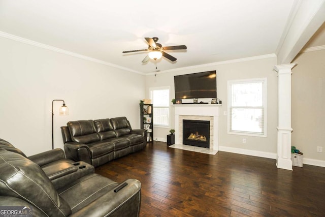 living room with ornamental molding, hardwood / wood-style floors, a fireplace with flush hearth, and decorative columns