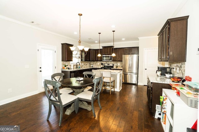 dining area featuring baseboards, ornamental molding, and dark wood finished floors