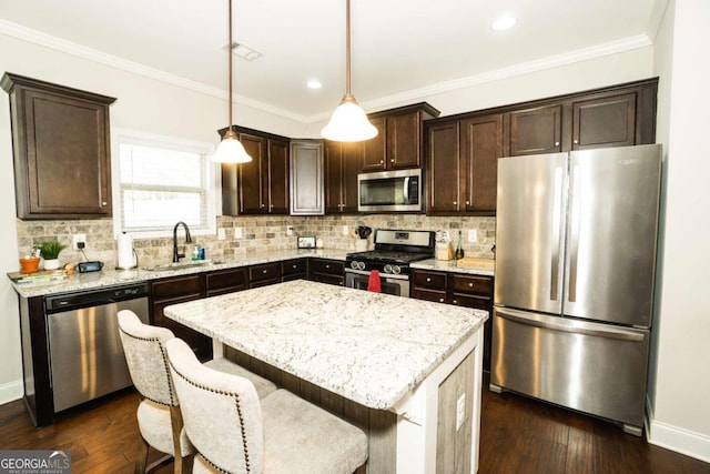 kitchen featuring dark brown cabinets, crown molding, stainless steel appliances, and a sink