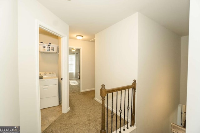 corridor featuring baseboards, washer / clothes dryer, light colored carpet, and an upstairs landing