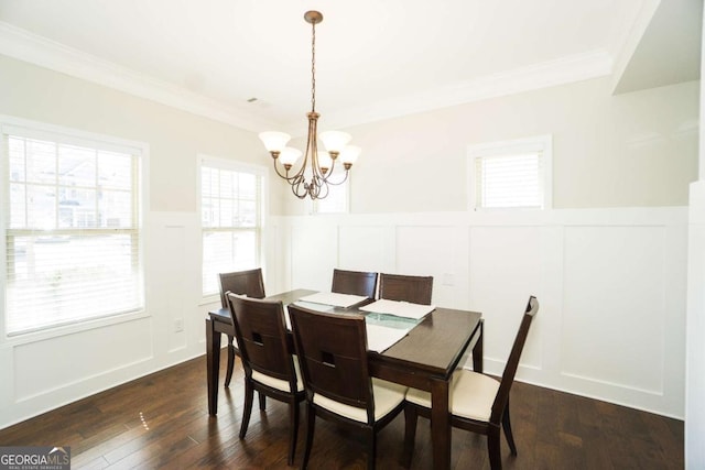 dining room featuring a wainscoted wall, dark wood-style flooring, a chandelier, and crown molding