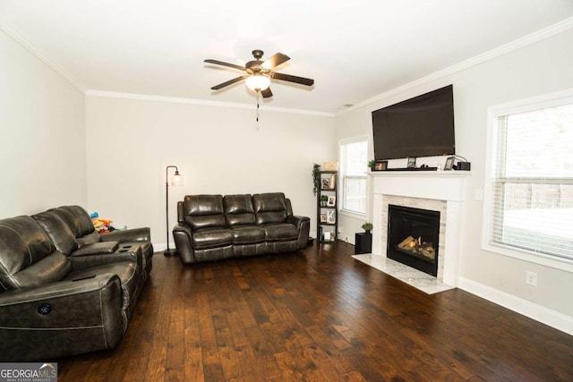 living room featuring ornamental molding, wood-type flooring, baseboards, and a fireplace with flush hearth