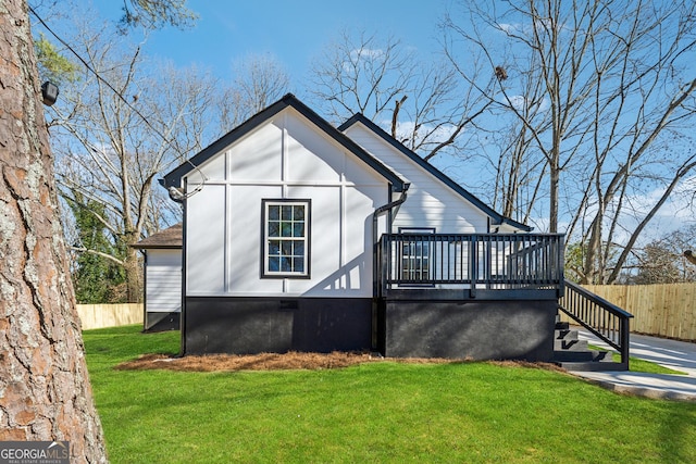 exterior space with a deck, a front yard, fence, and stairway