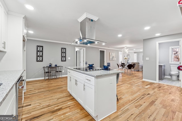 kitchen with crown molding, light wood-style flooring, island range hood, and black electric cooktop