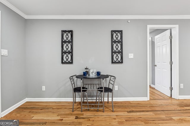 dining area featuring baseboards, ornamental molding, and wood finished floors