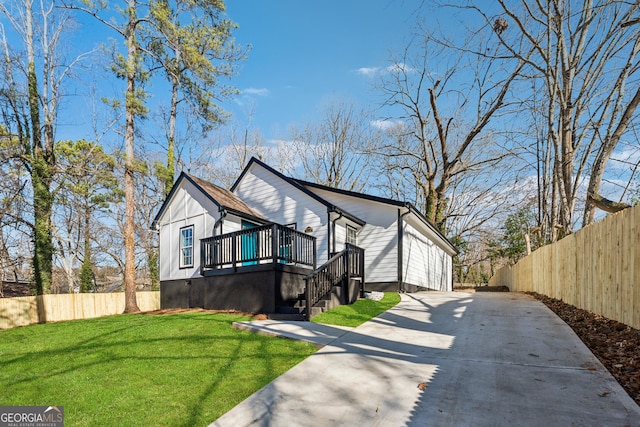 view of front of property with stairs, concrete driveway, a front lawn, and fence