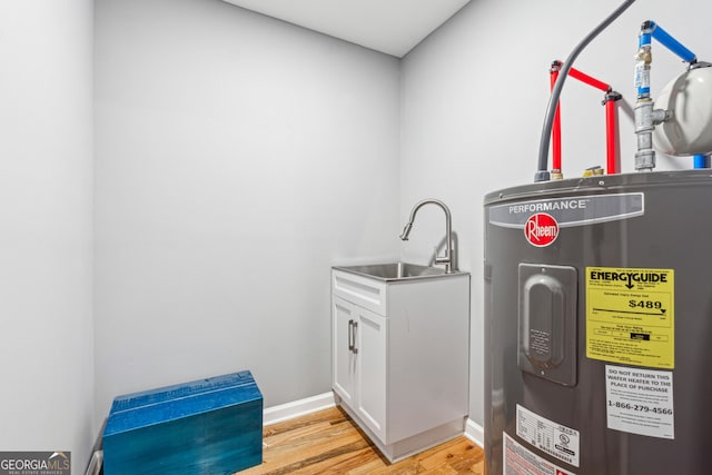 utility room with a sink and electric water heater