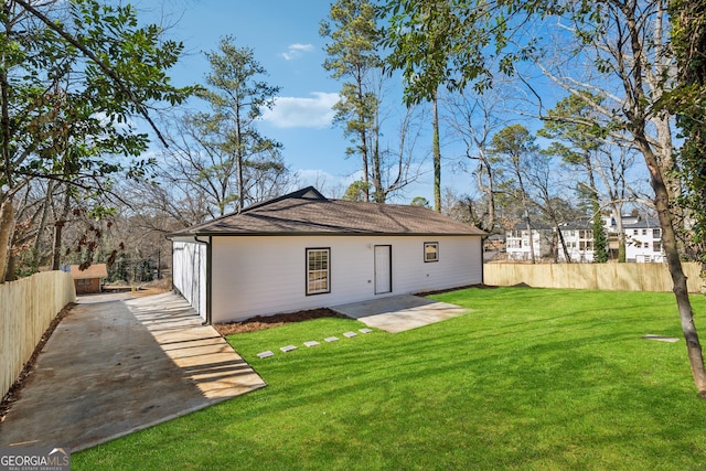 rear view of property with fence and a lawn