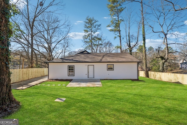 rear view of house with a patio area, a fenced backyard, and a lawn