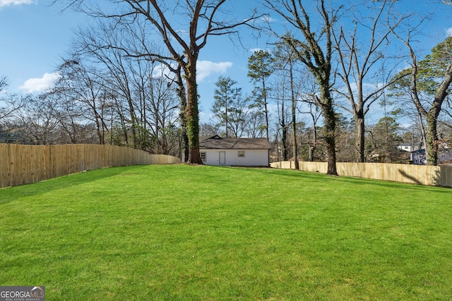 view of yard with a fenced backyard and an outbuilding