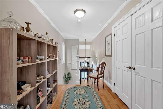 interior space with ornamental molding, light wood-style floors, and baseboards