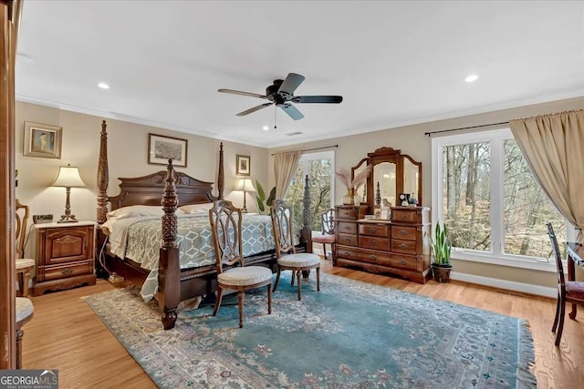 bedroom featuring baseboards, multiple windows, ornamental molding, and wood finished floors