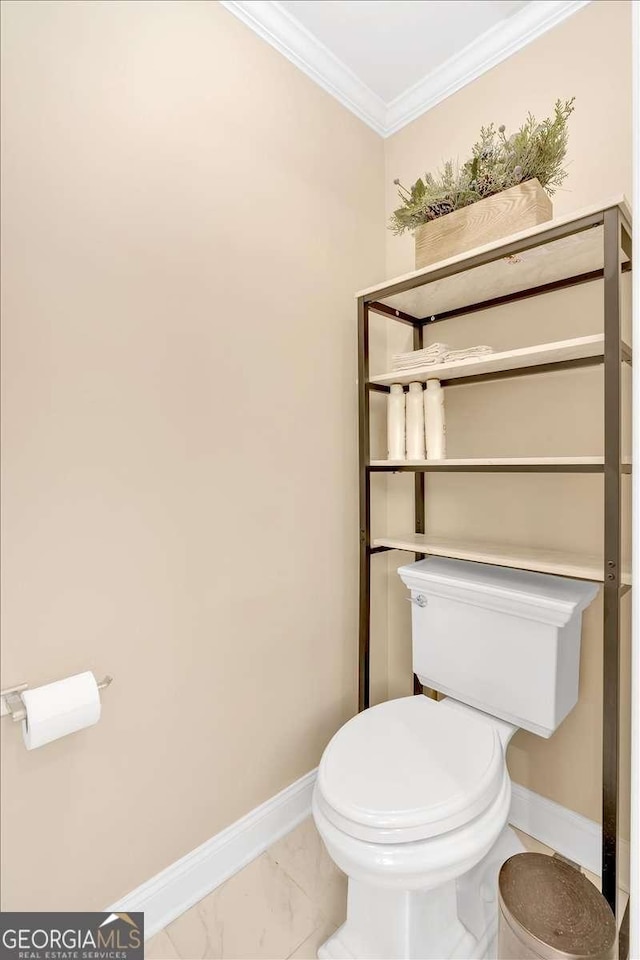 bathroom with toilet, marble finish floor, baseboards, and ornamental molding