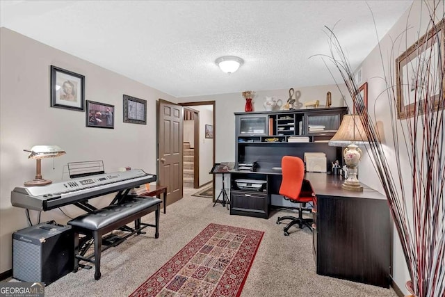 carpeted office space featuring a textured ceiling