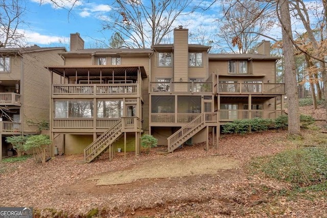 rear view of house featuring stairway and a chimney