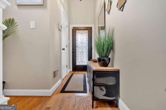 doorway to outside with visible vents, baseboards, and wood finished floors