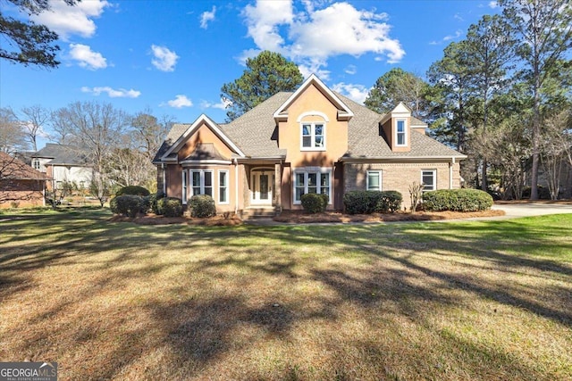 view of front of property with a shingled roof and a front lawn