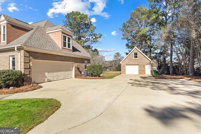 view of property exterior with a garage, brick siding, and roof with shingles