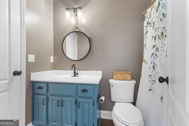 bathroom featuring toilet, vanity, and baseboards