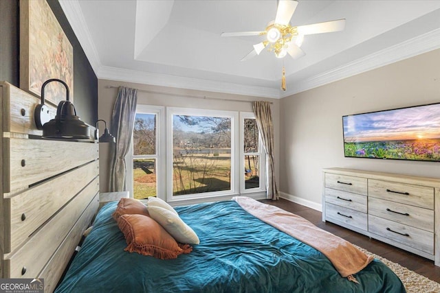 bedroom with dark wood finished floors, crown molding, a raised ceiling, ceiling fan, and baseboards