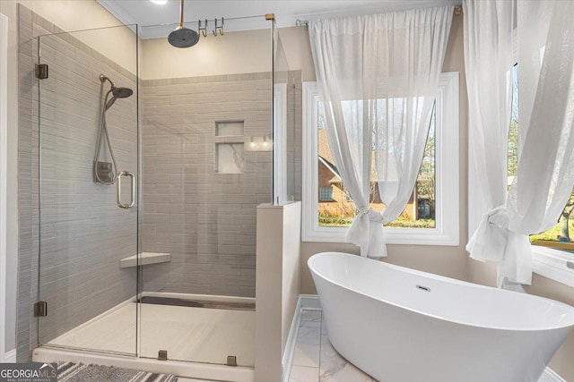 bathroom with marble finish floor, a shower stall, and a freestanding bath