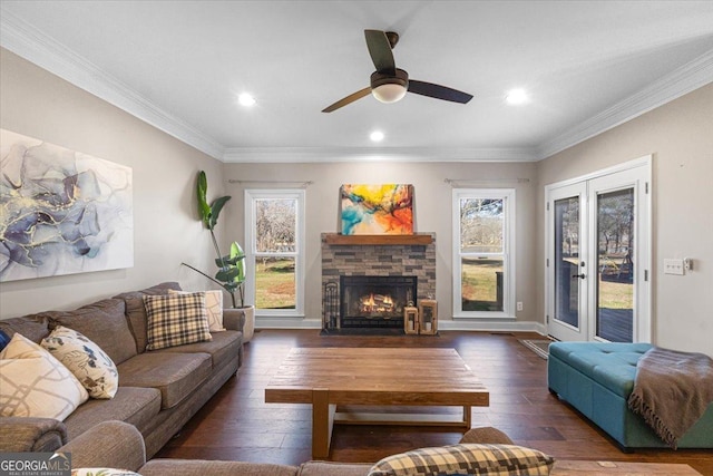 living area with baseboards, hardwood / wood-style floors, crown molding, french doors, and a fireplace