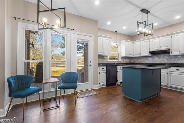 kitchen with dark countertops, white cabinetry, black dishwasher, and a chandelier