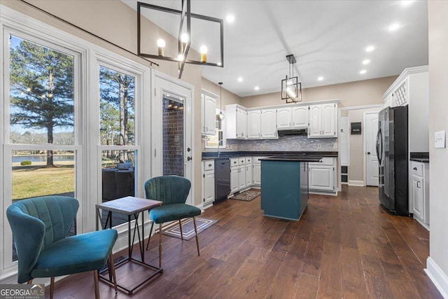 kitchen featuring a center island, dark countertops, backsplash, freestanding refrigerator, and dishwasher