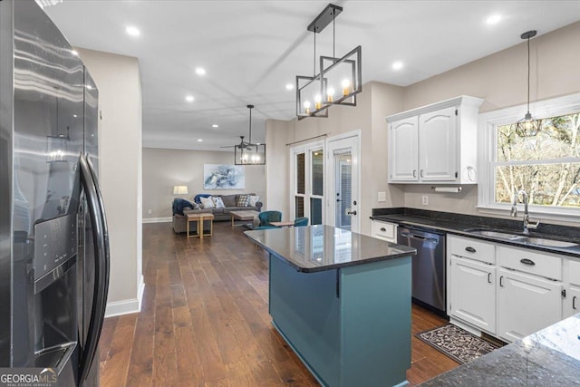 kitchen with white cabinets, dark wood finished floors, stainless steel appliances, and a sink