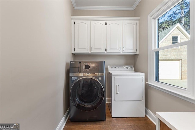 laundry area with crown molding, cabinet space, separate washer and dryer, wood finished floors, and baseboards