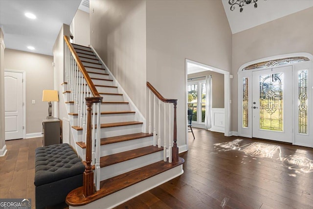 entryway featuring recessed lighting, hardwood / wood-style floors, high vaulted ceiling, baseboards, and stairs