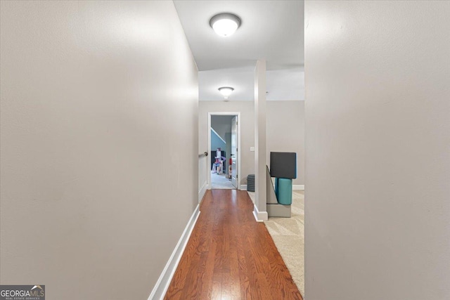 hall featuring wood finished floors and baseboards