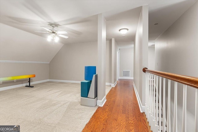 interior space with baseboards, visible vents, lofted ceiling, ceiling fan, and carpet