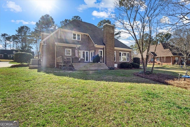 view of front of home with brick siding, a chimney, and a front yard